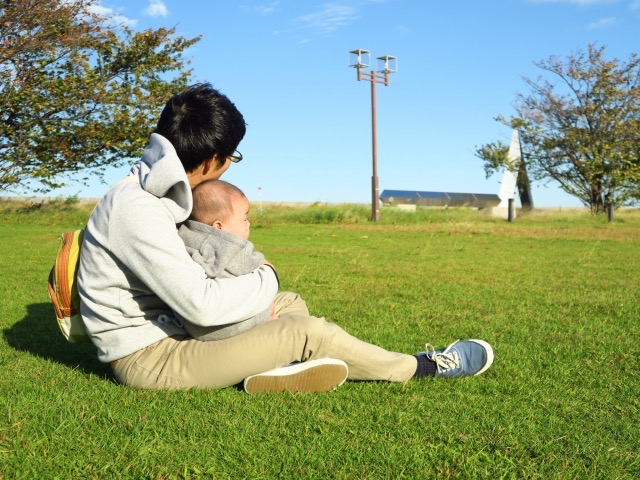 公園で子どもを抱いている男性